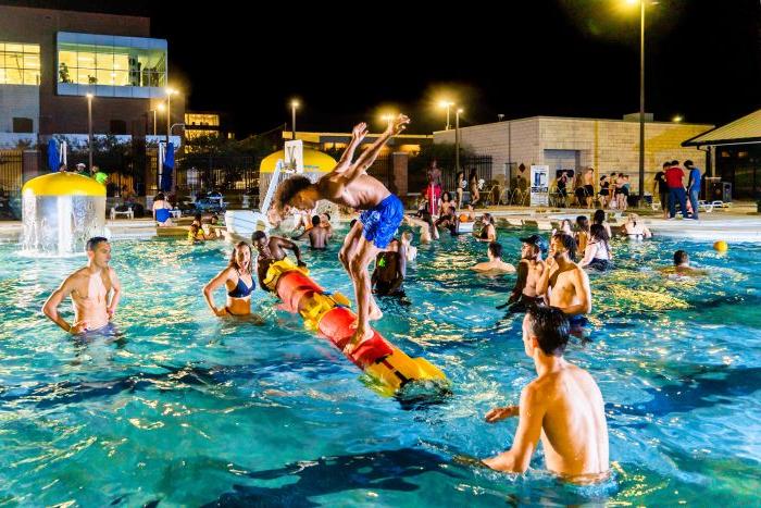 Group of students in swimming pool at night